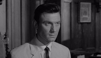 Movie still from “The Manchurian Candidate” (1962), directed by John Frankenheimer – Black and white photograph of a man wearing a suit; Close Up shot, Over the shoulder angle