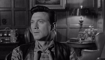 Movie still from “The Manchurian Candidate” (1962), directed by John Frankenheimer – A black and white photo of a man in a suit and tie; Close Up shot, Over the shoulder angle