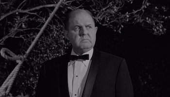 Movie still from “The Manchurian Candidate” (1962), directed by John Frankenheimer – An older man in a suit and bow tie; Close Up shot, Low angle