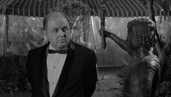 Movie still from “The Manchurian Candidate” (1962), directed by John Frankenheimer – A black and white photo of a man in a tuxedo; Medium shot, Over the shoulder angle