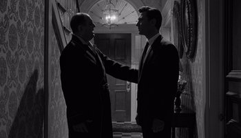Movie still from “The Manchurian Candidate” (1962), directed by John Frankenheimer – A couple of men standing next to each other in front of a door; Medium shot, Low angle