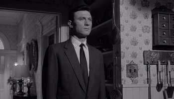 Movie still from “The Manchurian Candidate” (1962), directed by John Frankenheimer – Black and white photograph of a man in a suit; Medium shot, Low angle