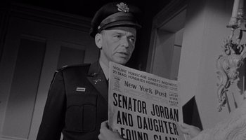 Movie still from “The Manchurian Candidate” (1962), directed by John Frankenheimer – A man in a military uniform holding a newspaper; Close Up shot, Over the shoulder angle