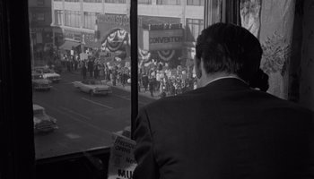 Movie still from “The Manchurian Candidate” (1962), directed by John Frankenheimer – A black and white photo of a man looking out of a bus window; Wide shot, High angle