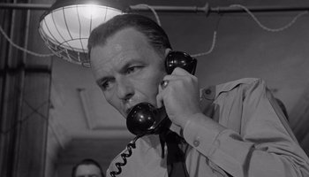 Movie still from “The Manchurian Candidate” (1962), directed by John Frankenheimer – A black and white photo of a man talking on a phone; Close Up shot, Low angle