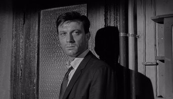 Movie still from “The Manchurian Candidate” (1962), directed by John Frankenheimer – Black and white photograph of a man in a suit; Close Up shot, Low angle