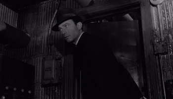 Movie still from “The Manchurian Candidate” (1962), directed by John Frankenheimer – A man wearing a hat standing in a room; Close Up shot, Low angle