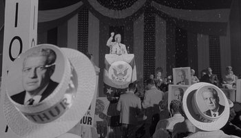 Movie still from “The Manchurian Candidate” (1962), directed by John Frankenheimer – An old photo of a man on a stage; Medium shot, Low angle