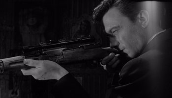Movie still from “The Manchurian Candidate” (1962), directed by John Frankenheimer – A black and white photo of a man holding a rifle; Close Up shot, Low angle