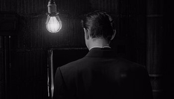 Movie still from “The Manchurian Candidate” (1962), directed by John Frankenheimer – A man standing in front of an illuminated light bulb; Close Up shot, Low angle
