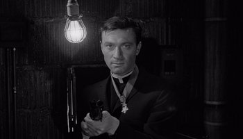Movie still from “The Manchurian Candidate” (1962), directed by John Frankenheimer – A man holding a gun in a room with a light fixture; Close Up shot, Low angle