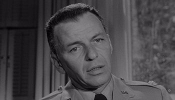 Movie still from “The Manchurian Candidate” (1962), directed by John Frankenheimer – An old black and white photo of a man in uniform; Close Up shot, Over the shoulder angle