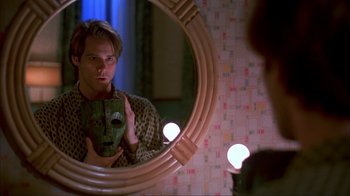 Movie still from “The Mask” (1994), directed by Chuck Russell – A man is looking at himself in the mirror; Close Up shot, Over the shoulder angle