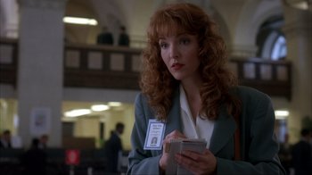 Movie still from “The Mask” (1994), directed by Chuck Russell – A woman holding a cell phone in her hands; Close Up shot, Over the shoulder angle