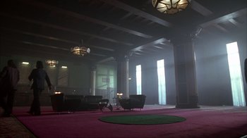Movie still from “The Mask” (1994), directed by Chuck Russell – A room filled with lots of furniture and large windows; Extreme Wide shot, High angle