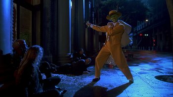 Movie still from “The Mask” (1994), directed by Chuck Russell – A man dressed in orange and holding a gun; Wide shot, Low angle