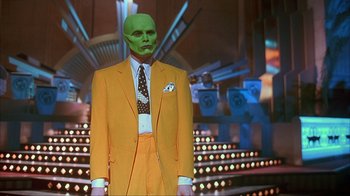Movie still from “The Mask” (1994), directed by Chuck Russell – A man in a yellow suit with a green mask; Medium shot, Low angle