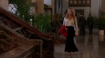Movie still from “The Mask” (1994), directed by Chuck Russell – A woman walking down the stairs in a building; Wide shot, Low angle