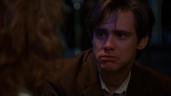 Movie still from “The Mask” (1994), directed by Chuck Russell – A person wearing a suit and tie; Close Up shot, Over the shoulder angle