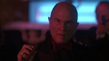 Movie still from “The Mask” (1994), directed by Chuck Russell – A bald man with a bow tie is holding a cane; Close Up shot, Low angle