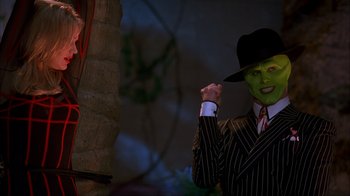 Movie still from “The Mask” (1994), directed by Chuck Russell – A man in a suit and a hat with a green face; Medium shot, Low angle