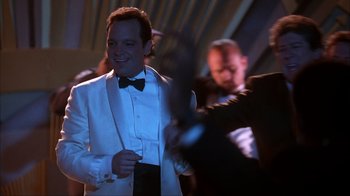 Movie still from “The Mask” (1994), directed by Chuck Russell – A man in a white suit and black bow tie; Medium shot, Low angle