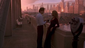Movie still from “The Mask” (1994), directed by Chuck Russell – A man and a woman standing next to a railing; Wide shot, High angle