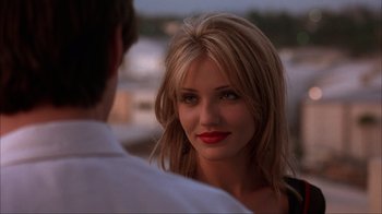 Movie still from “The Mask” (1994), directed by Chuck Russell – A woman with red lipstick looking at a man with blond hair; Close Up shot, Over the shoulder angle