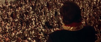 Movie still from “The Mask of Zorro” (1998), directed by Martin Campbell – A group of people sitting in a stadium watching a game; Extreme Wide shot, High angle