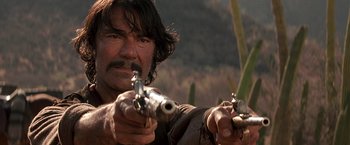 Movie still from “The Mask of Zorro” (1998), directed by Martin Campbell – A person holding a gun in a field; Close Up shot, Low angle