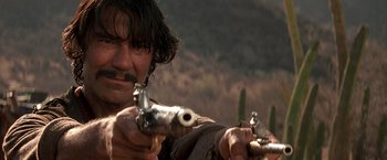 Movie still from “The Mask of Zorro” (1998), directed by Martin Campbell – A person holding a gun; Close Up shot, Low angle