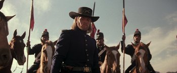 Movie still from “The Mask of Zorro” (1998), directed by Martin Campbell – A man in a military uniform standing next to a horse; Medium shot, Low angle