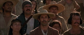 Movie still from “The Mask of Zorro” (1998), directed by Martin Campbell – A group of people wearing hats and standing in a crowd; Close Up shot, Low angle