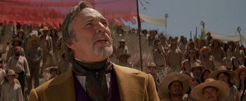 Movie still from “The Mask of Zorro” (1998), directed by Martin Campbell – An older man in a yellow jacket and a green neck tie; Close Up shot, Low angle