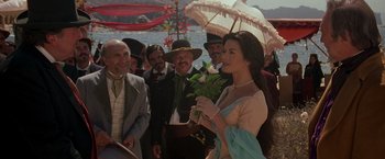 Movie still from “The Mask of Zorro” (1998), directed by Martin Campbell – A group of people standing next to each other holding an umbrella; Medium shot, Over the shoulder angle