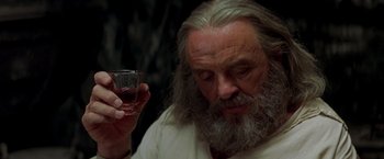 Movie still from “The Mask of Zorro” (1998), directed by Martin Campbell – An old man holding a wine glass in his right hand; Close Up shot, Low angle