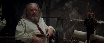 Movie still from “The Mask of Zorro” (1998), directed by Martin Campbell – An old man sitting at a table with a glass of wine; Close Up shot, Low angle