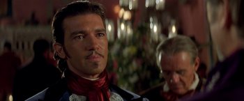 Movie still from “The Mask of Zorro” (1998), directed by Martin Campbell – A person wearing a suit and tie; Close Up shot, Over the shoulder angle