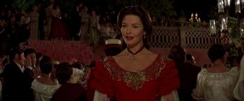 Movie still from “The Mask of Zorro” (1998), directed by Martin Campbell – A woman in a red dress with a heart on her chest; Close Up shot, Over the shoulder angle