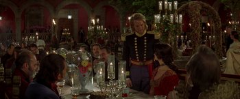 Movie still from “The Mask of Zorro” (1998), directed by Martin Campbell – A group of people sitting at a table with candles; Medium shot, Over the shoulder angle