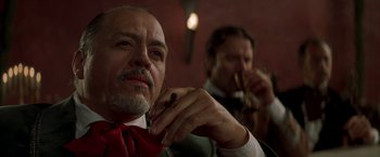 Movie still from “The Mask of Zorro” (1998), directed by Martin Campbell – A man in a suit and tie smoking a cigarette; Close Up shot, Low angle