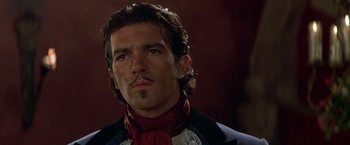 Movie still from “The Mask of Zorro” (1998), directed by Martin Campbell – A person wearing a suit and tie; Close Up shot, Low angle