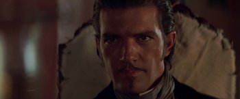 Movie still from “The Mask of Zorro” (1998), directed by Martin Campbell – A person wearing a suit and tie; Close Up shot, Over the shoulder angle