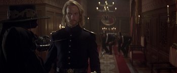 Movie still from “The Mask of Zorro” (1998), directed by Martin Campbell – A man in a military uniform standing in a room; Medium shot, Over the shoulder angle