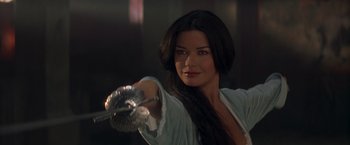 Movie still from “The Mask of Zorro” (1998), directed by Martin Campbell – A beautiful woman holding a brush in her right hand; Close Up shot, Over the shoulder angle