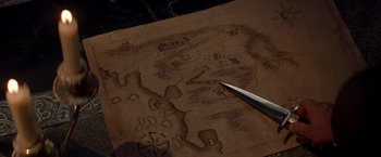 Movie still from “The Mask of Zorro” (1998), directed by Martin Campbell – An old map is being drawn with a knife; Extreme Close Up shot, Overhead angle