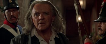 Movie still from “The Mask of Zorro” (1998), directed by Martin Campbell – An older man with long hair and a beard; Close Up shot, Over the shoulder angle