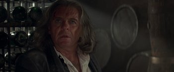 Movie still from “The Mask of Zorro” (1998), directed by Martin Campbell – An older man with long hair looking at the camera; Close Up shot, Low angle