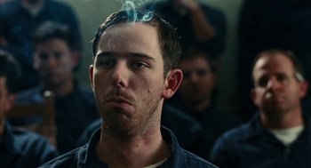 Movie still from “The Master” (2012), directed by Paul Thomas Anderson – A young man smoking a cigarette in front of a group of people; Close Up shot, Low angle