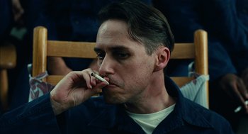 Movie still from “The Master” (2012), directed by Paul Thomas Anderson – A person holding a cell phone to his ear; Close Up shot, Low angle